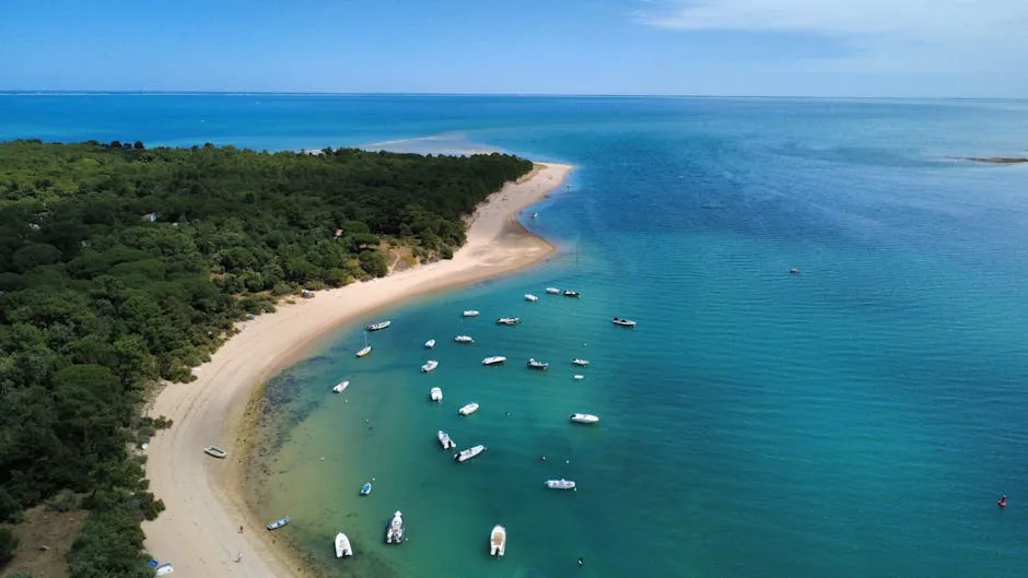 Aerial view of a tranquil sandy beach with boats in Les Portes-en-Ré, France.